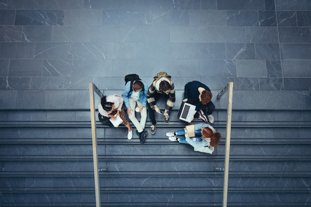 Students studying on stairs at college