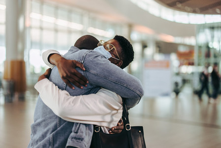 Tourist couple giving goodbye hug at airport