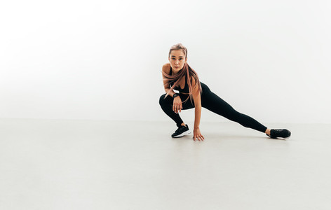 Sportswoman doing stretching exercises indoors before training