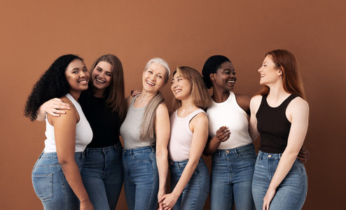 Cheerful women of different body types and ages standing together in studio