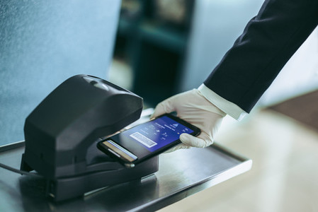 Hand of airport staff scanning boarding pass