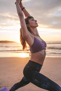 Fit woman stretching at the beach