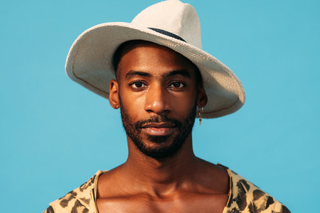 Close up portrait of a handsome man in hat against a blue background
