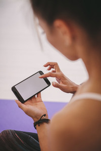 Woman using mobile phone at fitness studio