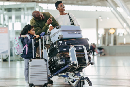 Family at airport with their luggage on trolley