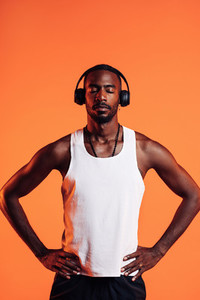 African American male athlete listening music through wireless headphones  Man in sportsclothes relaxing during fitness training