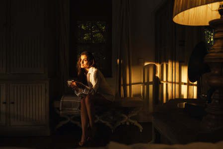 Tourist woman relaxing in a dark hotel room
