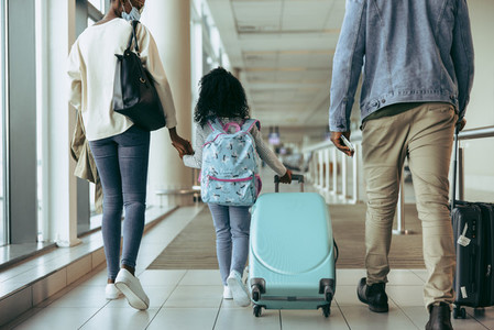 Family of three with luggage at airport