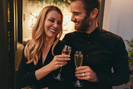 Cheerful couple toasting with champagne glasses