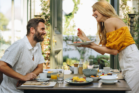 Romantic woman going in to feed her husband during breakfast