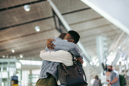 Man and woman giving good bye hug at airport