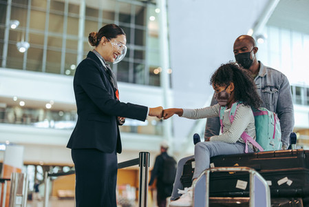Airport staff greeting small girl with fist bump