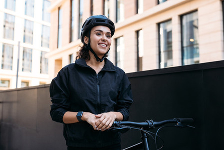 Portrait of a young female standing with a bicycle  Delivery woman taking a break during a working day