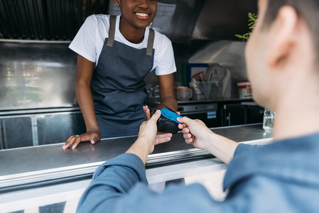 Close up of male customer apply a credit card to POS terminal at a food truck