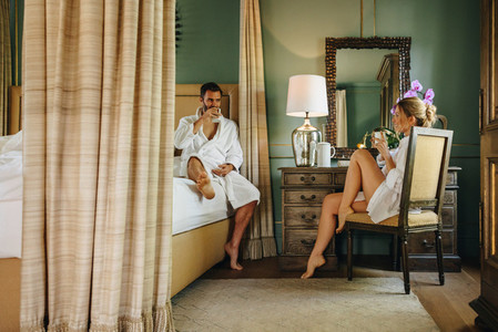 Cute couple having coffee in a luxury hotel room