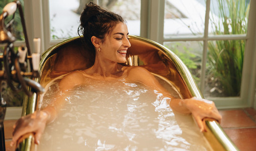 Smiling young woman enjoying a refreshing bath