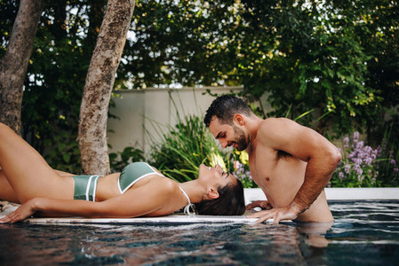 Honeymooners flirting at a luxury swimming pool