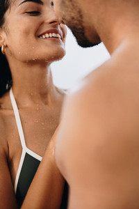 Young couple flirting under an outdoor shower