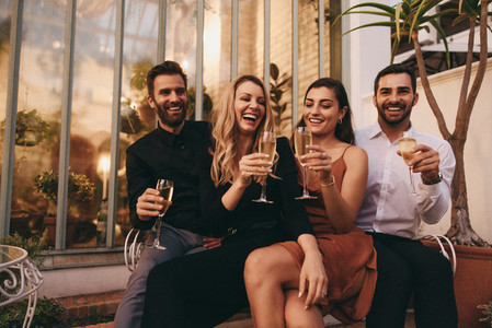 Four friends raising wineglasses cheerfully