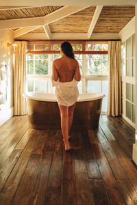 Woman going for a luxury bath in a hotel room