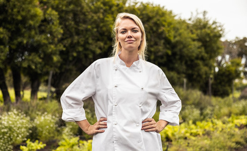 Chef standing with her arms crossed in a farm field