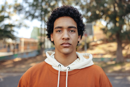 Portrait of a teenage boy standing in an urban park
