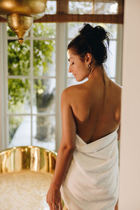 Beautiful young woman preparing for a bath in her hotel room