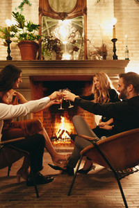 Toasting glasses by the fireplace