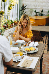 Woman laughing while having brunch with her husband