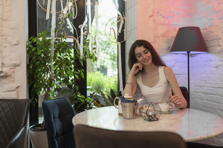 Young woman enjoying tea at cafe table
