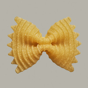 Close up uncooked farfalle bow tie pasta noodle on gray background