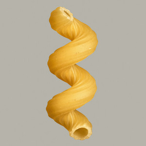 Close up uncooked fusilli pasta noodle on gray background
