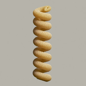 Close up uncooked fusilli bucati pasta noodle on gray background