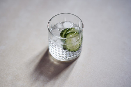 Glass of ice water with cucumber slices