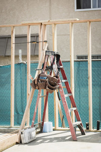 Tool belt hanging on ladder at construction site