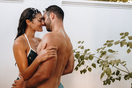 Couple flirting under the shower outdoors