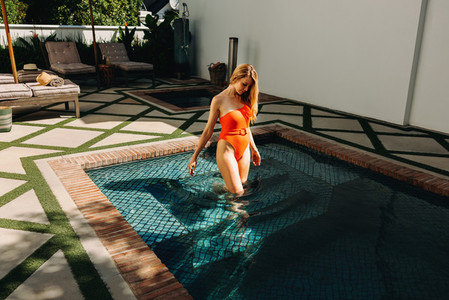 Woman stepping into a swimming pool at a spa