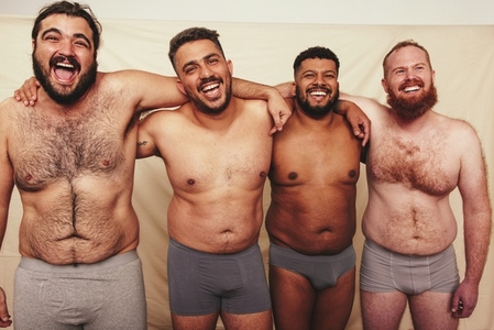 Studio shot of shirtless men embracing each other