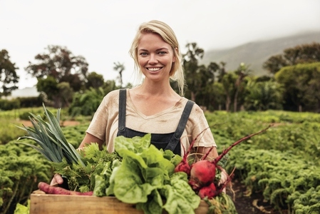 Vegetable farmer smiling cheerfully after harvest