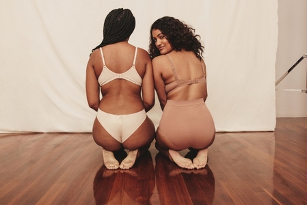 Two confident young women kneeling in underwear