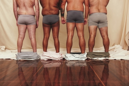 Anonymous men standing with their shorts dropped down