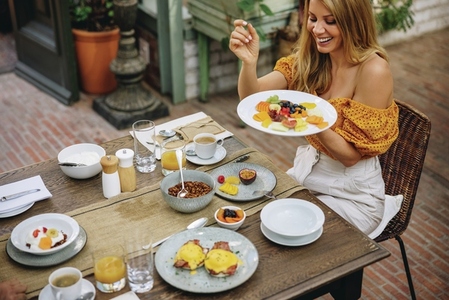 Cheerful woman enjoying a healthy breakfast at a luxury hotel