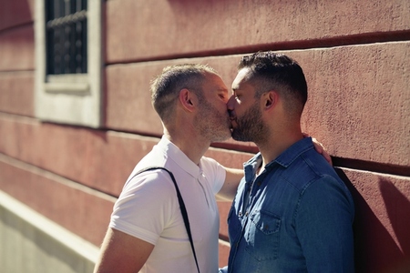 Gay couple kissing outdoors in urban background