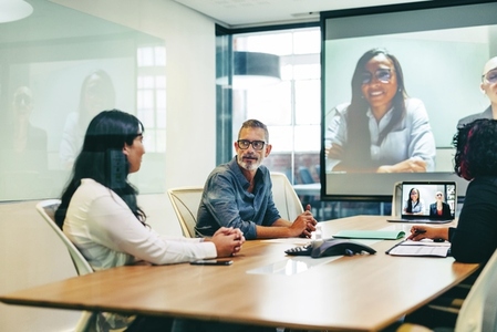 Businesspeople having a virtual meeting with their partners in a boardroom