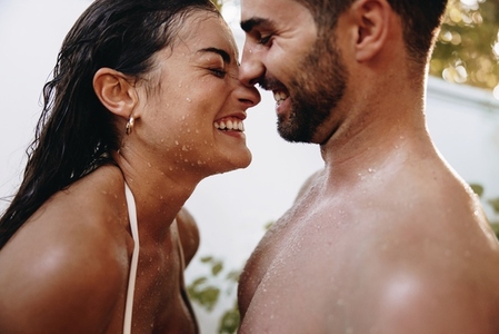 Playful couple having fun under an outdoor shower