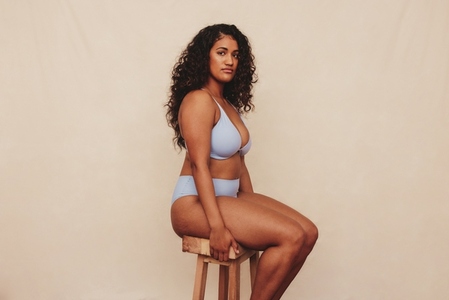 Body positive young woman sitting comfortably in a blue underwear