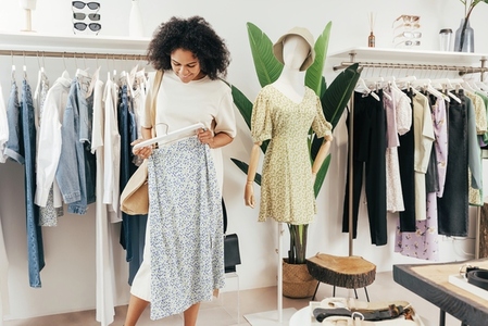 Stylish woman choosing dress in a boutique