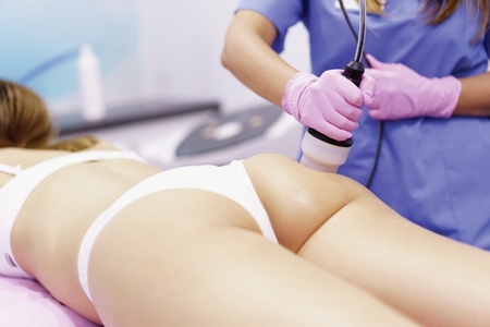 Woman receiving anti cellulite treatment with radiofrequency machine in a beauty center