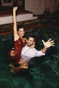 Couple smiling and cheering in a swimming pool