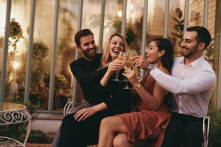 Carefree group of friends celebrating with sparkling wine